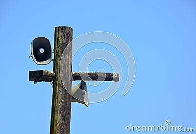 Pair of metal old vintage horn speaker for public relations on wood post covered with green moss and lichen Stock Photo