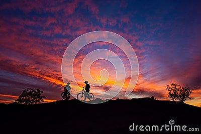 Mountain bikers silhouetted against a colorful sunset sky in South Mountain Park, Phoenix, Arizona. Stock Photo