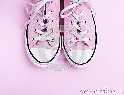 Pair of old worn pink sneakers with white laces Stock Photo