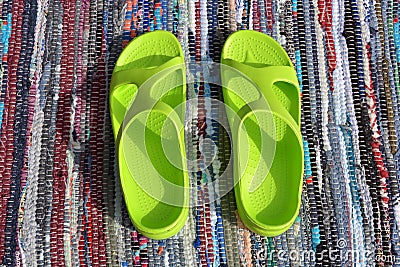 Pair plastic green sandals on handmade carpet background Stock Photo