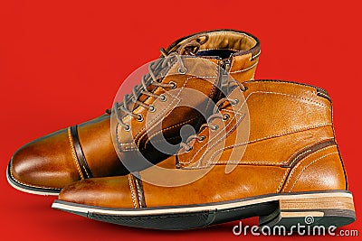 A pair of premium calfskin boots on a red background. Horizontal shot. Stock Photo