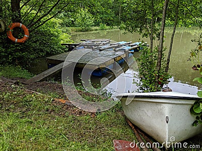 A pair of rafts on a pontoon with a small rowing boat on the shore bank Stock Photo