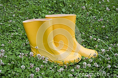 Pair rain rubber yellow boots on grass Stock Photo