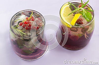 Pair of red forest fruit coctails with ice, lemon and sliced fru Stock Photo