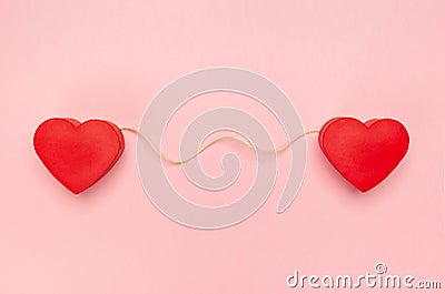 Pair of red hearts connected with a string of twine Stock Photo