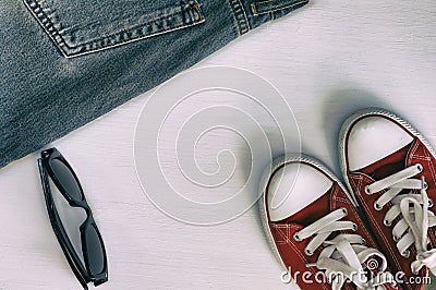 Pair of red sneakers, retro fragment jeans, black sunglasses on Stock Photo