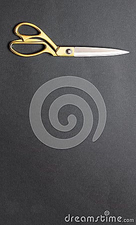 Pair of scissors gold handle isolated on black background, top view Stock Photo