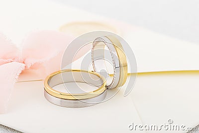 Pair of silver and gold combined rings on beige invitation envelope Stock Photo