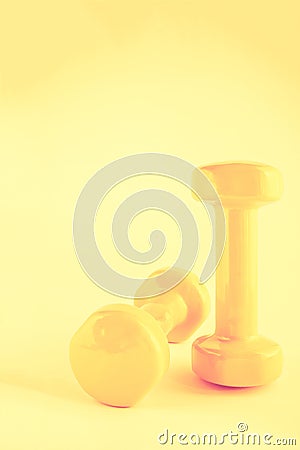 Pair of small yellow dumbbells Stock Photo