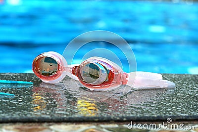 Pair of swimming goggles beside a swimming pool Stock Photo