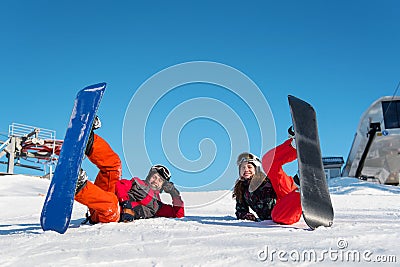 Pair with their snowboards lying in snow on ski slope Stock Photo