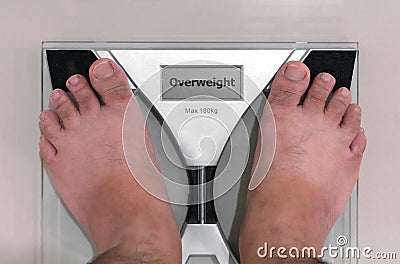 Pair of Ugly Feet on a Floor Scale with `Overweight` on the Disp Stock Photo