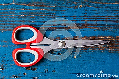 A pair of used children scissors against old blue wooden background Stock Photo