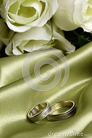 Pair of wedding bands on green satin Stock Photo