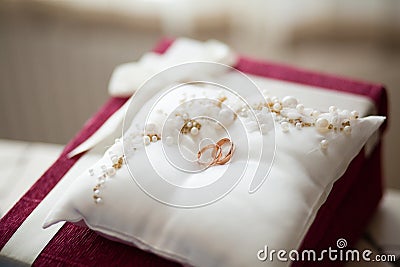 A pair of wedding rings on a white pillow Stock Photo