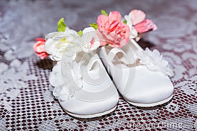 Pair of white baby shoes on pants and shirt at Christening Baptism Ceremony at church chapel Stock Photo