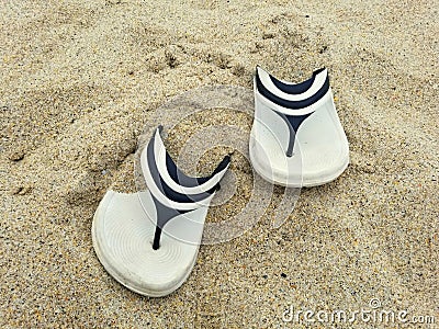 A pair of white and black sandals on the beach Stock Photo