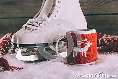 White skates with cup with knitted ornament and scarf Stock Photo