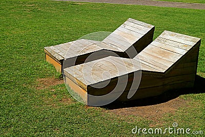 Pair of wooden benches on the lawn in the sunlight in public park Stock Photo