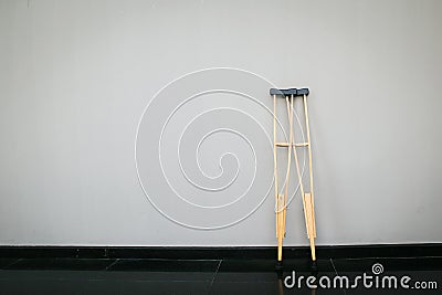 Pair wooden crutches or medical walking sticks for rehabilitation of broken leg. Stock Photo