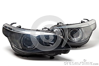 A pair of xenon headlights for a German auto - optical equipment with a lens and corrector inside on a white isolated background. Stock Photo