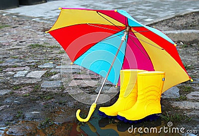 Pair of yellow rubber boots with an open umbrella Stock Photo