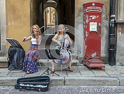 A pair of young musicians perform in the Old Town of Warsaw in Poland. Editorial Stock Photo