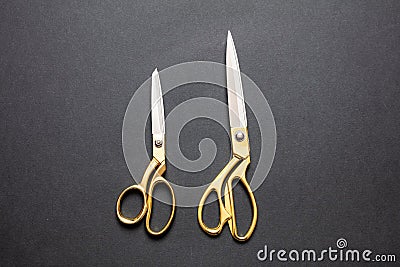 Pairs of scissors gold handle isolated on black background, top view Stock Photo