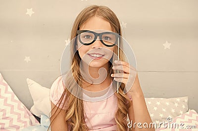 Pajamas party concept. Girl eyeglasses at pajamas party. Cheerful kid posing eyeglasses. Photo booth props ideas Stock Photo