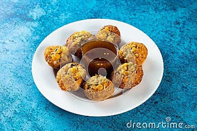 Pakistani spicy gol gappay, indian pani puri and bangali fuchka full of chaat masala with sour water in a dish isolated on marble Stock Photo