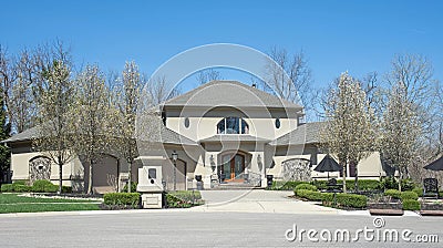 Palatial Luxury Home in Gray Stucco with Flowering Pear Trees Stock Photo