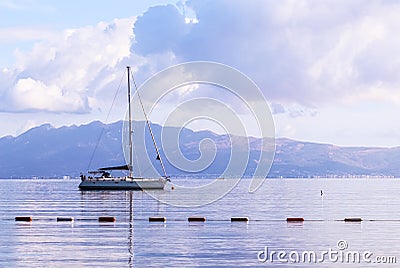 Pale purple sea, boat and mountains at sunrise. Coastal nature background Editorial Stock Photo