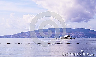 Pale purple sea, boat and mountains at sunrise. Coastal nature background Stock Photo