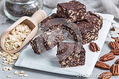 Paleo chocolate energy bars with rolled oats, pecan nuts, dates, chia seeds and coconut flakes Stock Photo