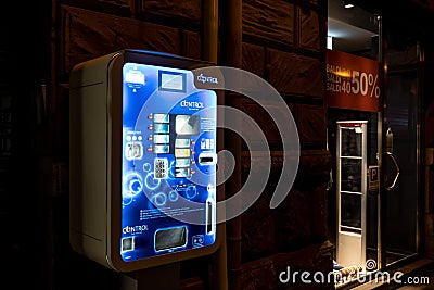 The condom vending machine to prevent venereal disease and for birth control with bright blue colours at night Editorial Stock Photo