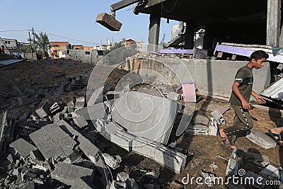 Palestinians gather around the remains of a house destroyed in an Israeli air strike Editorial Stock Photo