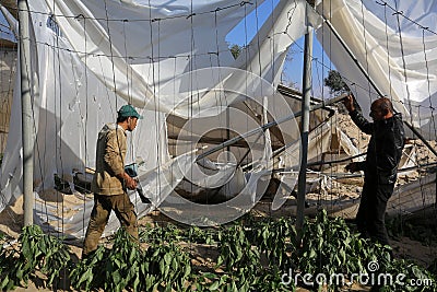 Palestinians inspect the damage at the site of an Israeli air strike Editorial Stock Photo