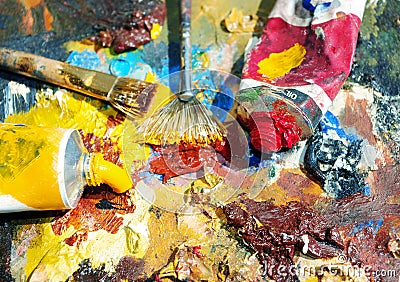 Palette of the artist with tubes of paint and brushes. Stock Photo