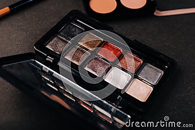 Palette of old eye shadow on a black background. The contents of a handbag. Makeup brush tool. Dusty makeup Stock Photo