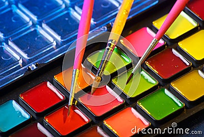 Palette of watercolor paints with three brushes Stock Photo