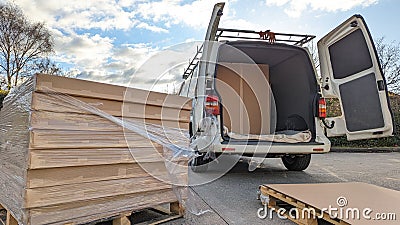 A pallet stacked with boxes being packed into a white van Stock Photo