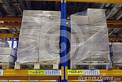 Pallets with boxes stand on a shelf goods warehouse. Editorial Stock Photo