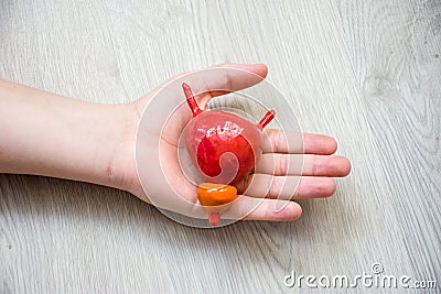 In palm of hand lying on wooden floor, is anatomical model of gastric or stomach. Concept photo depicting stomach illness such as Stock Photo