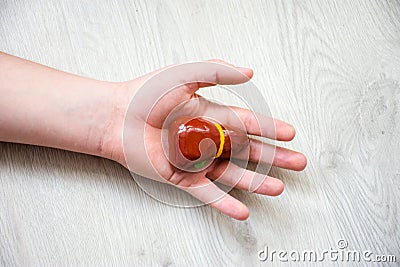 In palm of hand lying on wooden floor, is anatomical model of liver or hepar. Concept photo depicting liver illness such as cancer Stock Photo