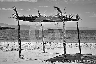 Palm leaves thatched shed with four pillars in an ocean Stock Photo