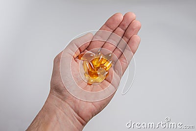 In the palm of the yellow translucent medicine capsules Stock Photo