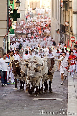 PAMPLONA, SPAIN-JULY 9: Bulls and men running in street during S Editorial Stock Photo