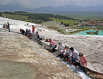 Pamukkale, Turkey - April 26, 2015: Tourists feet immersed in water flows coming from the travertine terraces Editorial Stock Photo