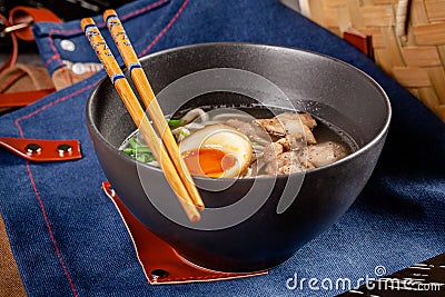Pan-Asian cuisine concept. Japanese Ramen Soup with Chinese Noodles, Egg, Chicken and Green Onions. Serving dishes Stock Photo