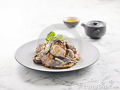 Pan-fried Grouper fish Belly with Mushroom Sauce served in a dish side view on grey background Stock Photo